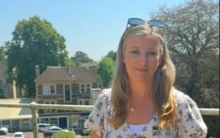 Sara Thornton - Senior weather presenter stands in front of blue skies 
