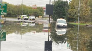 Burst water pipe floods road and buildings and cuts off supplies - BBC News