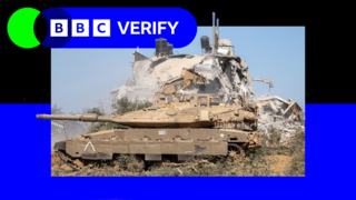 An Israeli tank parked next to the ruins of a building in the Gaza Strip.