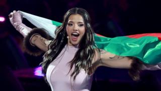 Eurovision winner Dara carries the Bulgarian flag behind her