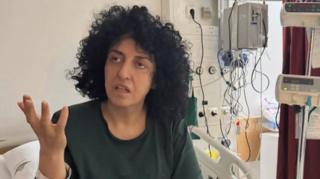 An undated photograph posted by lawyer Chirinne Ardakani showing Iranian Nobel Prize-winning human rights activist Narges Mohammadi gesturing from a hospital bed in Iran (10 May 2026)