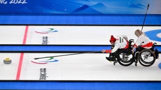 Wheelchair curlers use a delivery stick to push the stone