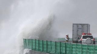 Waves crash against coastal road in north east Japan