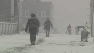 Pedestrians walk through heavy falling snow in Istanbul