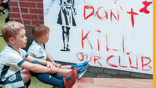 Two boys in front of a banner