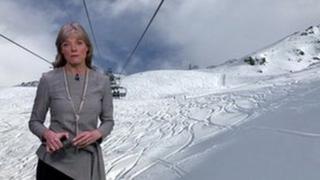 Louise Lear stands in front of a background showing a ski slope