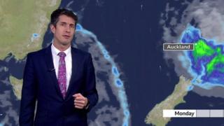 Chris Fawkes stands in front of a weather map of New Zealand showing storm Gabrielle
