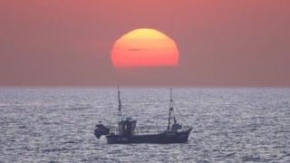 Boat on water at sunrise