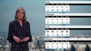 Louise Lear standing in front of a table of weather temperatures in Ukraine