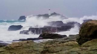 Waves crashing near a lighthouse