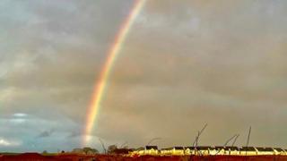 Cloudy grey sky with a partial rainbow