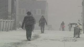 Pedestrians walk through heavy falling snow in Istanbul