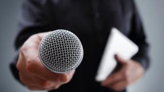 man holding out microphone