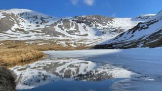 Snow covered hill tops with blue sky behind