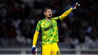 Arijanet Muric in a yellow Sassuolo goalkeeping kit shouts at his defenders during a game