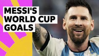 Lionel Messi in a Argentina shirt with his arms up and smiling
