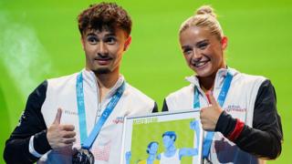 Great Britain team-mates Jake Jarman and Ruby Evans pose for a photo on the podium after winning silver at the 2025 European Artistic Gymnastics Championships