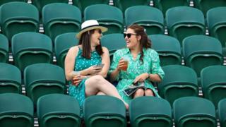 Two women sat among empty seats at Wimbledon