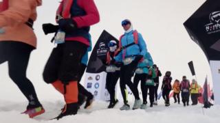 Runners set off from the snowy starting line in full thermal gear and goggles