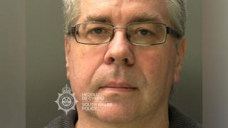 A mugshot of Christopher Phillips, who has grey hair and glasses