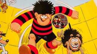 Dennis the Menace with Gnasher, and the coin is seen between them