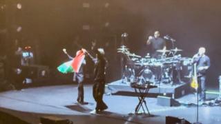 Massive Attack band members holding Palestine flag on stage in Singapore