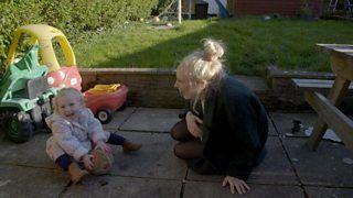 A mum sat outside with her toddler daughter.