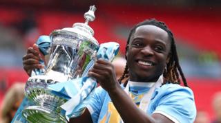 Manchester City Jeremy Doku smiles as he holds the FA Cup