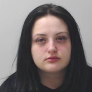 A mugshot of a young woman with long dark hair. 