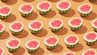 Rows of halved watermelons on a pale orange background