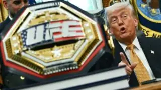 Donald Trump gestures to a gold UFC prize belt.