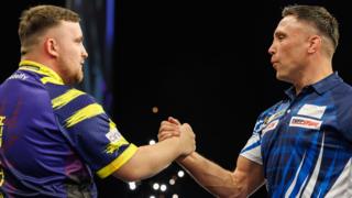 Luke Littler shakes hands with Gerwyn Price