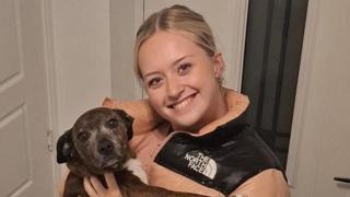 Menyw ifanc yn gafael mewn ci