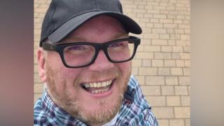 Damien Paul Bintley, a man with a beard, dark glasses and a black cap.