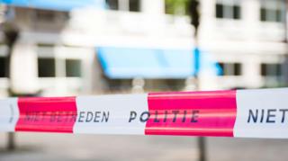 A stock image of white-and-red striped Dutch police tape, which reads 'Politie'.