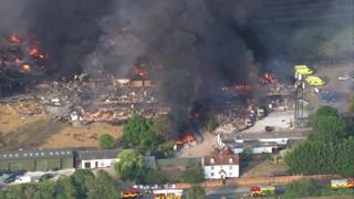 Aerial view shows fires burning and thick black smoke over industrial site