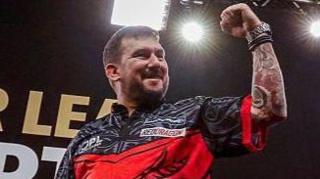 Jonny Clayton celebrates with a clenches fist and smile