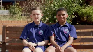 Two boys sitting on a bench.
