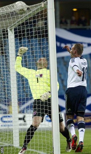 Rhodes heads in the opening goal despite goalkeeper Jonathan Joubert's attentions