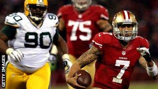 Colin Kaepernick of the San Francisco 49ers (right) powers through the Green Bay defence