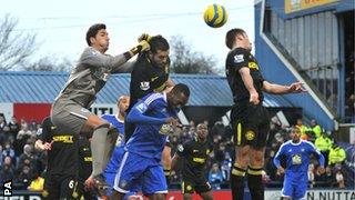 Wigan goalkeeper Joel Robles (left) clears the ball under pressure on his debut