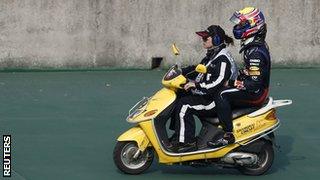 Red Bull driver Mark Webber gets a lift back to the pits after losing his right-rear wheel