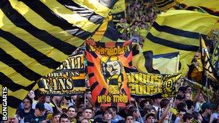 Dortmund fans waving flags during the recent game against Bayern Munich