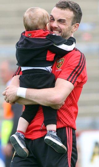 Down forward Conor Laverty gets a hug from his son Setanta after the Mourne men defeated Derry 2-17 to 1-15