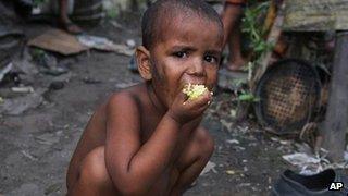 An Indian child eats rice in a slum in Guwahati in Assam on 4 July 2013