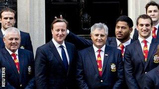 England centre Manu Tuilagi makes a gesture behind Britain's Prime Minister David Cameron (centre), as he poses with the British and Irish Lions rugby squad