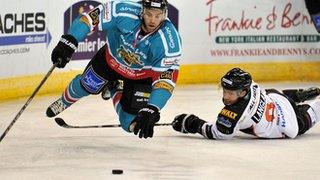 Evan Cheverie of the Belfast Giants is tripped by Chad Langlais, former Giants player and now of the Sheffield Steelers during the Elite League game at the Odyssey Arena in Belfast