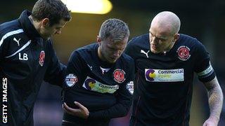 Fleetwood striker David Ball is helped off the field at Northampton