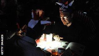 Spectators use their phones to read programmes during the Lakeside power cut