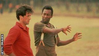 Pele attempts to teach Stallone some goalkeeping skills during the filming of 'Escape to Victory'